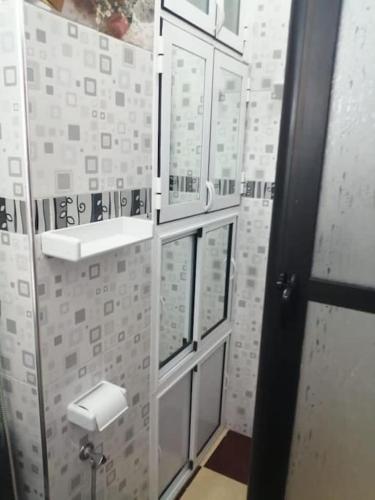 a bathroom with white and gray tiles on the wall at Prestige, Luxe au Centre Ville in Agadir
