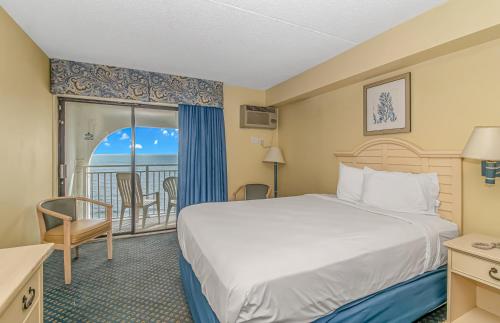 um quarto de hotel com uma cama e uma varanda em Direct Oceanfront Sea Mist Resort 21101 em Myrtle Beach