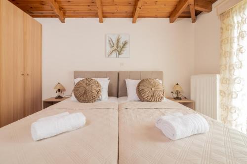 a bedroom with two beds with white sheets and pillows at Villa Pergola in Pandokrátor