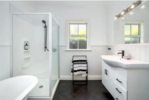 a white bathroom with a sink and a shower at Karoo House in Greytown