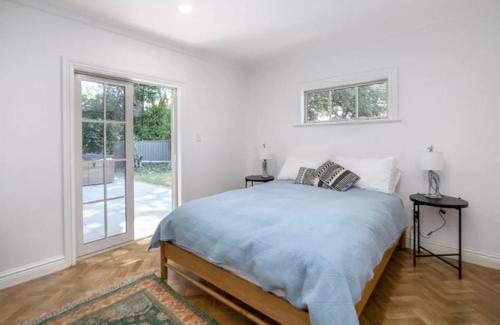 a white bedroom with a bed and a window at Karoo House in Greytown