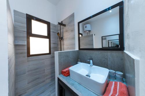 bagno con lavandino e specchio di ChezBabo Wellness Hotel a Ngaparou