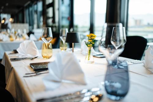 a table with wine glasses and napkins on it at voco Villach by IHG in Villach