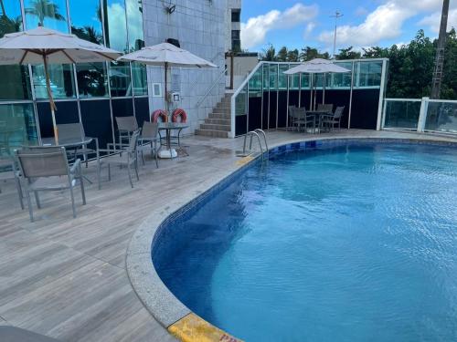 duży basen z leżakami i parasolami w budynku w obiekcie 2906 Cobertura Beira Mar Av Boa Viagem w mieście Recife