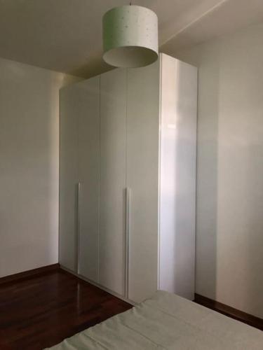 a bedroom with a bed and a white cabinet at Il Gelsomino; appartamento ampio e luminoso in Santarcangelo di Romagna