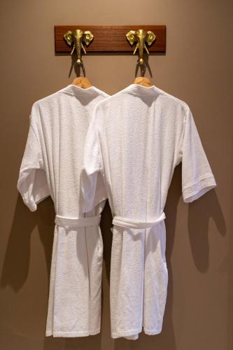 two white towels are hanging on a towel rack at Eutopiq Hotel in Medellín