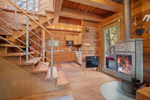 a log home with a staircase and a fireplace at Srub Pod Lípou - Skryje 