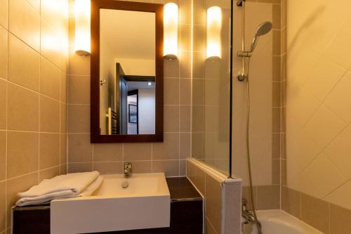 ein Bad mit einem Waschbecken, einer Dusche und einem Spiegel in der Unterkunft MC Tourisme - Splendide & cosy appartement avec piscine, tennis & parking in Le Touquet-Paris-Plage