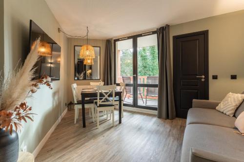 un salon avec une table et une salle à manger dans l'établissement MC Tourisme - Splendide & cosy appartement avec piscine, tennis & parking, à Le Touquet-Paris-Plage