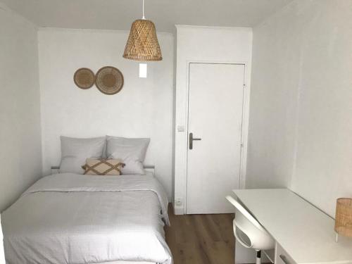 ランスにあるAppartement cosy - Reimsの白いベッドルーム(ベッド1台、デスク、ランプ付)