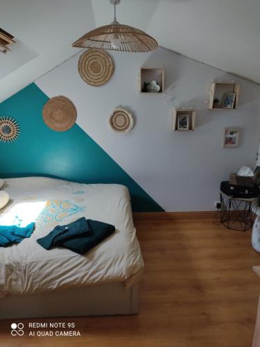 - une chambre avec un mur bleu et blanc et un lit dans l'établissement Familly 10 min du circuit 15 min de boulerie jump et 1h30 de Paris Saint Arnoult en voiture ou 55 min en train pensez aux JO, à Changé