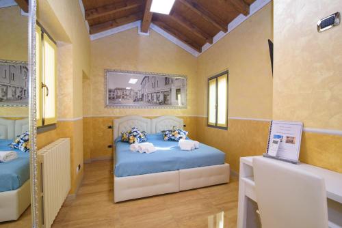 a room with two beds and a desk in it at Appartamenti S Onofrio Rho in Rho