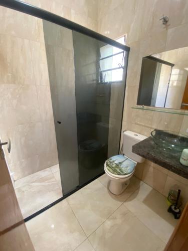 a bathroom with a shower and a toilet and a sink at Apartamento Bela vista II in Guaratinguetá