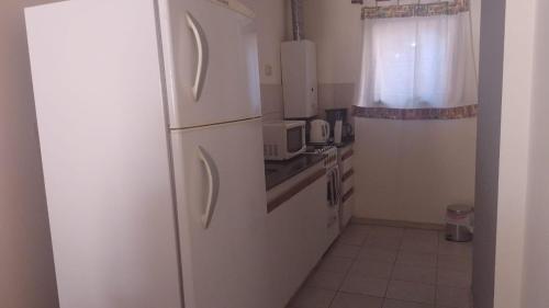 a white refrigerator in a kitchen with a window at Dpto dos dormitorios en Nueva Córdoba in Cordoba
