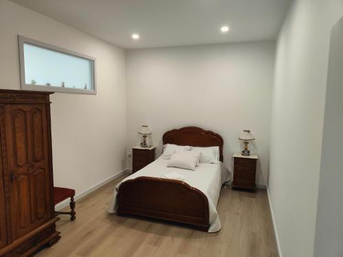 a bedroom with a bed and two night stands and a window at Quinta de Basto House in Felgueiras