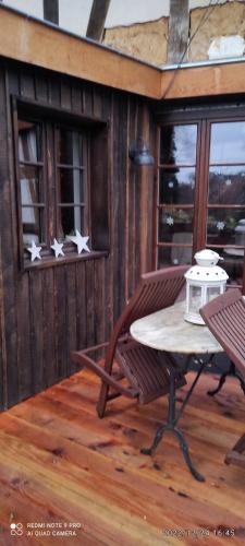 a screened in porch with a table and two chairs at GITE AU PETIT RUISSEAU-Etage et combles-maison alsacienne 4 personnes 4 nuitées minimum in Langensoultzbach