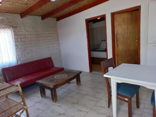 a living room with a red couch and a table at Ckoinatur Hostel in San Pedro de Atacama