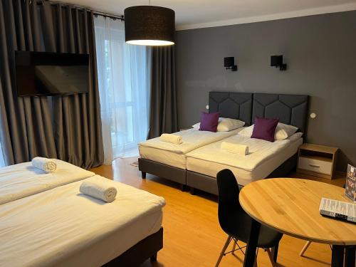 a hotel room with two beds and a table at WRZOS resort & wellness in Węgierska Górka