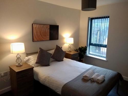 1 dormitorio con 1 cama con 2 toallas en 2 Bed Flat Near Deansgate, en Mánchester