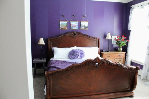 a bedroom with a bed with a purple wall at The Nordic Pineapple Bed and Breakfast in Saint Johns