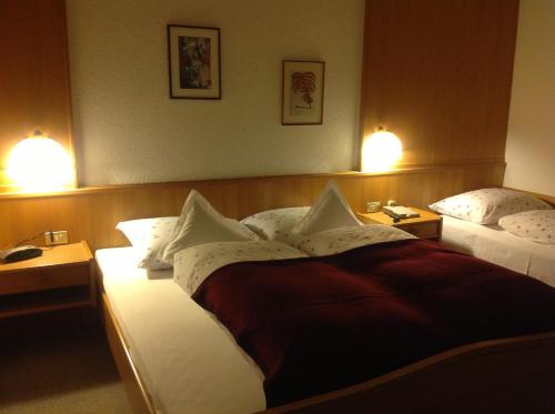 a hotel room with two beds and two lamps at Hotel Garni Lichtenau in Schenna