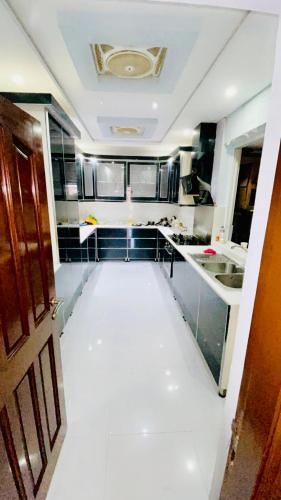 una grande cucina con pavimento bianco e porta di Mirpur Villa a Pothi