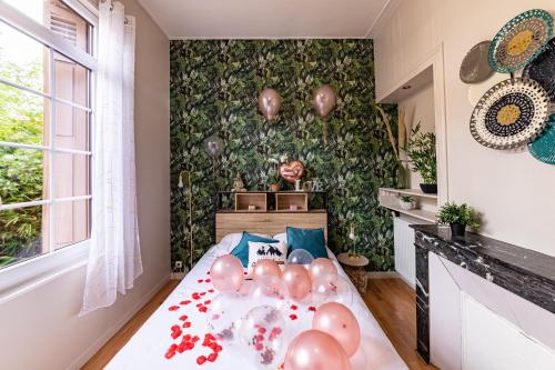 Suite Amazonia ~ Balnéo ~ Arrivée Autonome في رووين: غرفة نوم مع مجموعة من البالونات على سرير