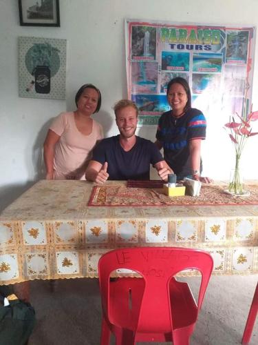 a group of three people sitting at a table at Paraiso Hostel Moalboal in Moalboal