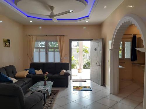 sala de estar con sofá y techo con luces azules en Babhilds Residence, en Bakau