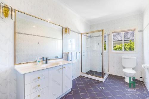 雪梨的住宿－Central Coast Moon Lake Resort，一间带水槽、淋浴和卫生间的浴室