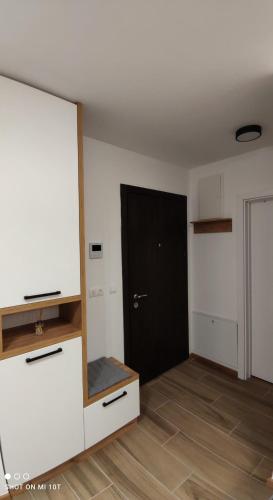 an empty room with a black door and a room with a floor at Apartman Danica in Pale