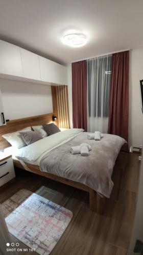 a bedroom with a large bed with two towels on it at Apartman Danica in Pale