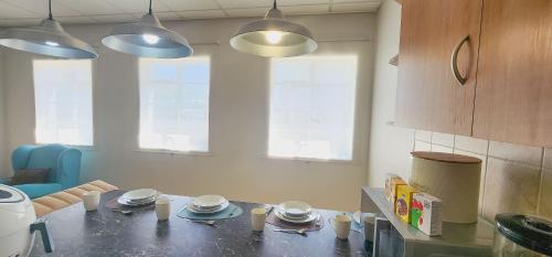 a kitchen with a table with cups and plates on it at The Tipsy Expat in Paarl