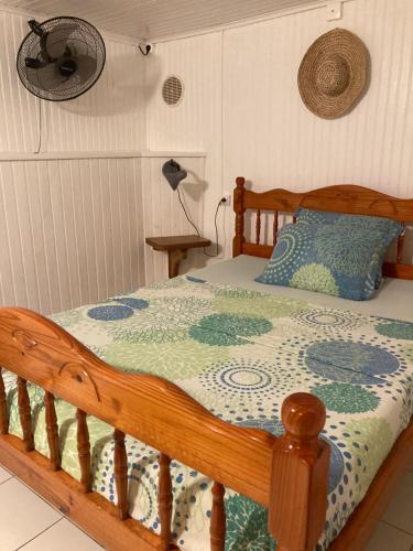 a wooden bed with a blue and green quilt on it at LE VILLAGE DE CANADA in Faup