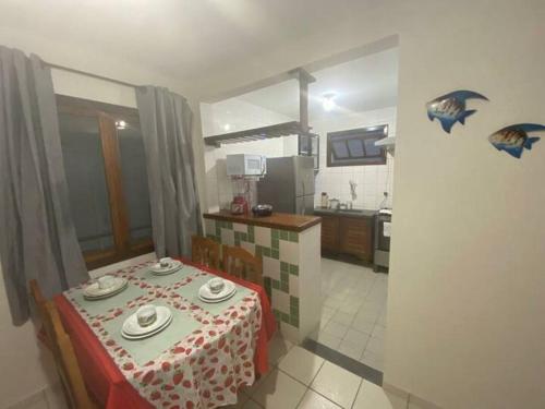 a room with a table and a kitchen with a tableablish at Pé na Areia in Porto Seguro