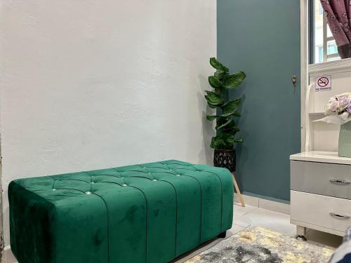 a green ottoman in the corner of a room at Bandar Melaka Family Bungalow Private Pool BBQ WiFi Netflix in Malacca