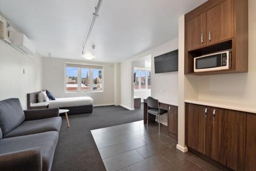 a living room with a couch and a microwave at Allurity Hotel in Hobart