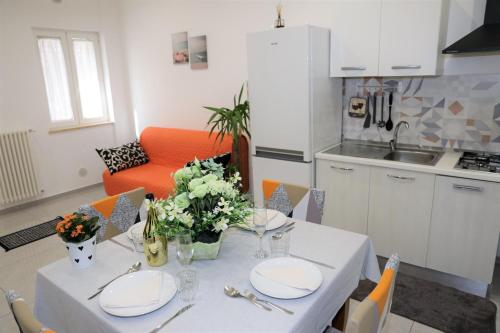 d'une cuisine avec une table avec des assiettes et des fleurs. dans l'établissement Apulia Modern apartment - Bari Airport, à Bitonto