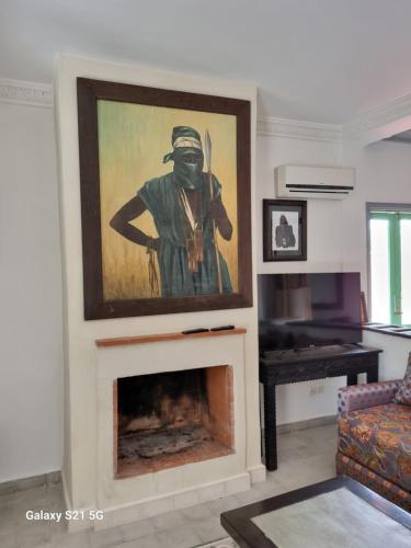a living room with a painting of a man wearing a gas mask at Riad les deux citronniers in Marrakesh