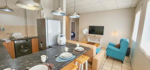 a kitchen and living room with a table and blue chair at The Tipsy Expat in Paarl