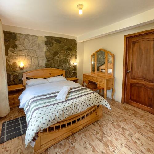 een slaapkamer met een groot bed en een spiegel bij Quinta San Martín in Cuenca