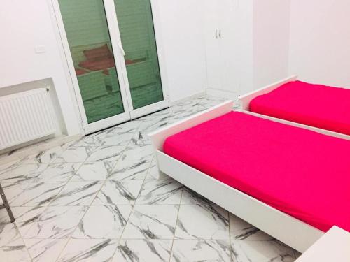 a bedroom with a red bed and marble floor at Nouveau Appartement Avec Un Parking Gratuit in La Marsa