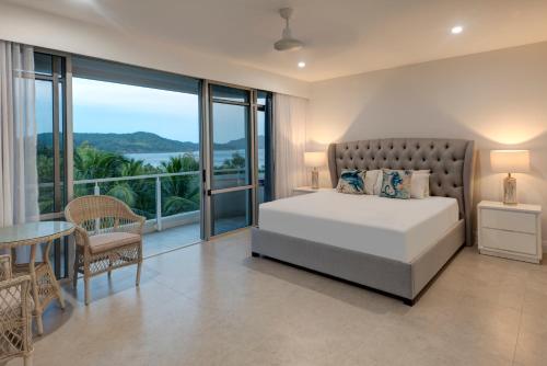 1 dormitorio con 1 cama y balcón en Allure on Hamilton Island by HIHA, en Hamilton Island