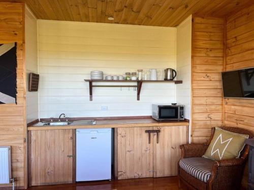 a kitchen with a counter with a sink and a microwave at Pt Hesse Luxury Coastal Homestead in Port Campbell