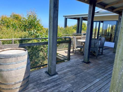 a wooden deck with a table and chairs on a house at Pt Hesse Luxury Coastal Homestead in Port Campbell