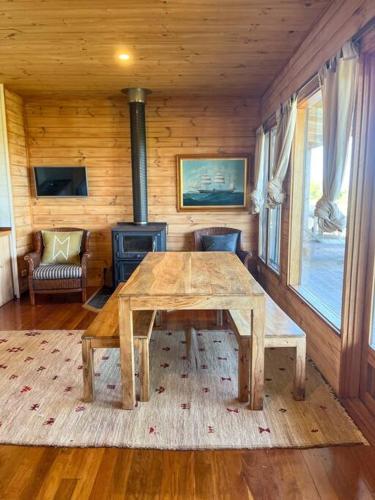 a wooden room with a table and a wood stove at Pt Hesse Luxury Coastal Homestead in Port Campbell