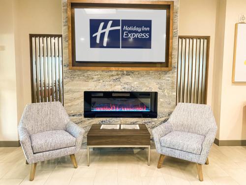 a living room with a fireplace and two chairs at Holiday Inn Express & Suites Frazier Park by IHG in Lebec