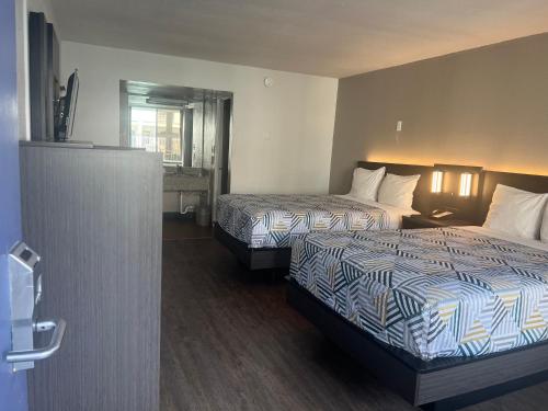 a hotel room with two beds and a bathroom at Motel 6 Glendale Phoenix in Glendale