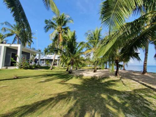 dom na plaży z palmami w obiekcie Anajawan Island Beachfront Resort w mieście General Luna