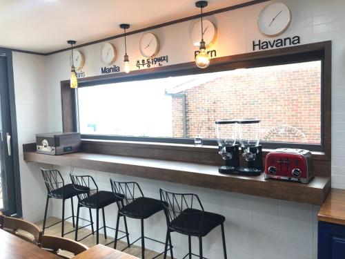 a bar in a restaurant with black chairs and a counter at Cheukhu-dong 19street Guesthouse in Mokpo